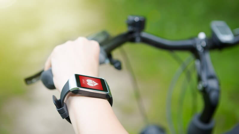 Arm mit Smartwatch zur Messung der Herzfrequenz während des Fahrradfahrens