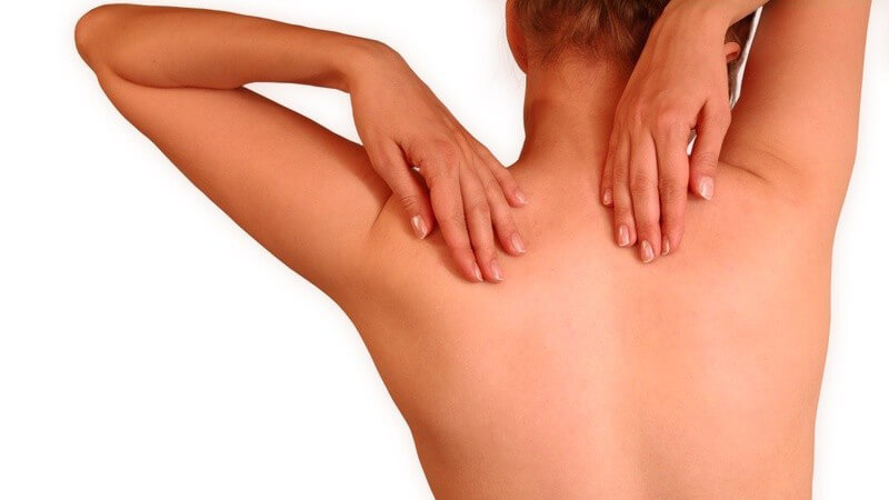 Frau fasst sich mit beiden Händen an den nackten Rücken