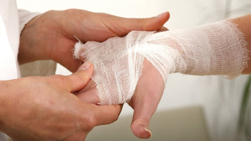 Frauenarm bekommt Verband um Handgelenk