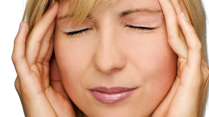 Nahaufnahme junge Frau mit Kopfschmerzen hält sich die Schläfen