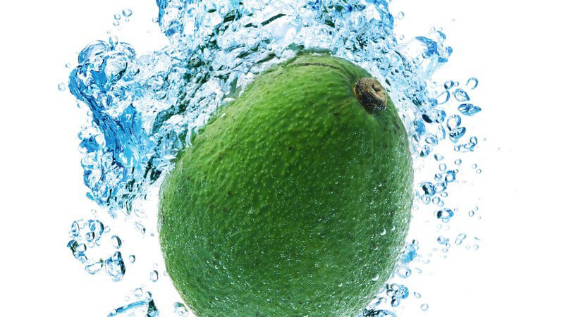 Avocado fällt ins Wasser und hinterlässt Wasserblasen unter Oberfläche