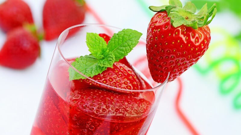 Glas mit Erdbeerbowle und frischen Erdbeeren
