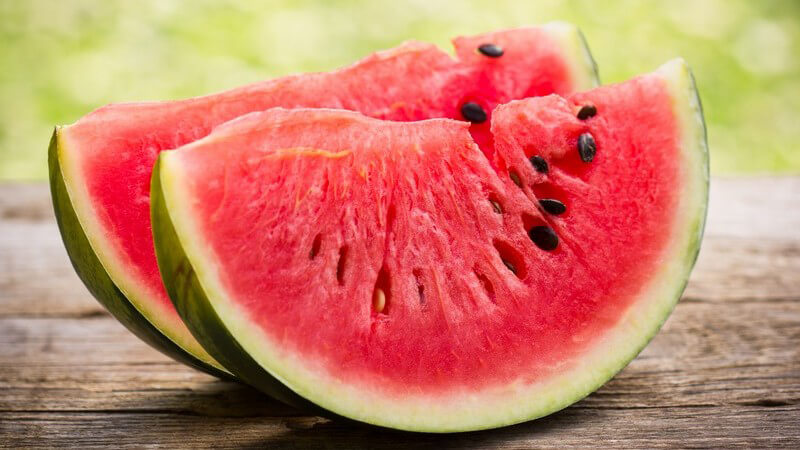 Zwei Stücke Wassermelone auf Holztisch