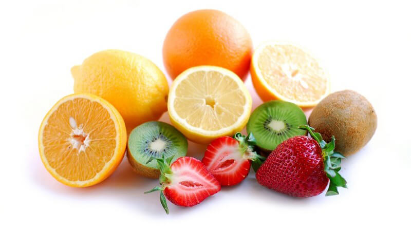 Frisches Obst auf weißem Hintergrund: Orangen, Kiwis, Erdbeeren