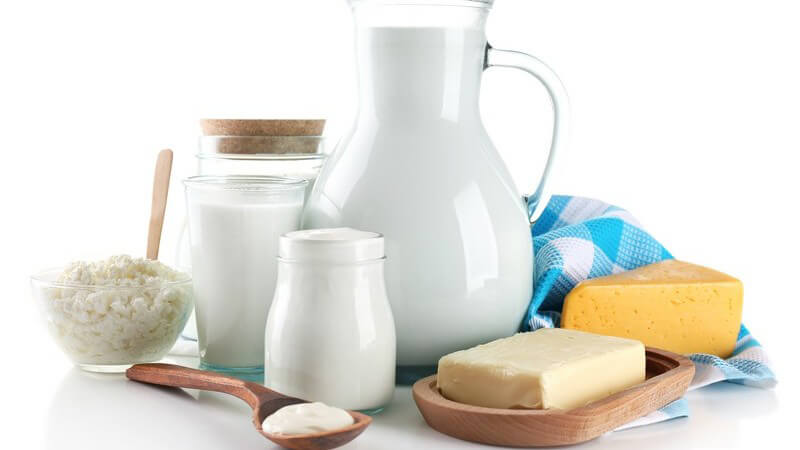 Milchprodukte vor weißem Hintergrund - Milchkaraffe, Butter, Käse und Mager...